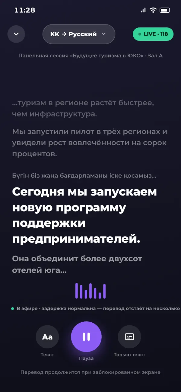 Экран живого перевода: переключатель «KK → Русский», транскрипт речи спикера, звуковая волна и кнопка паузы
